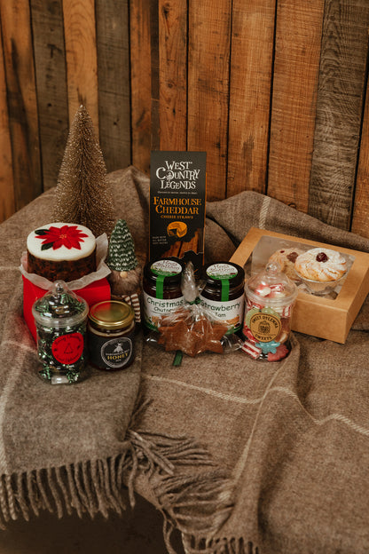 Assorted food items including jam, chutney,christmas cake and sweets with a rustic background.