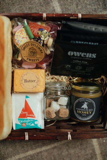 Gift basket with sweet treats, coffee, and honey